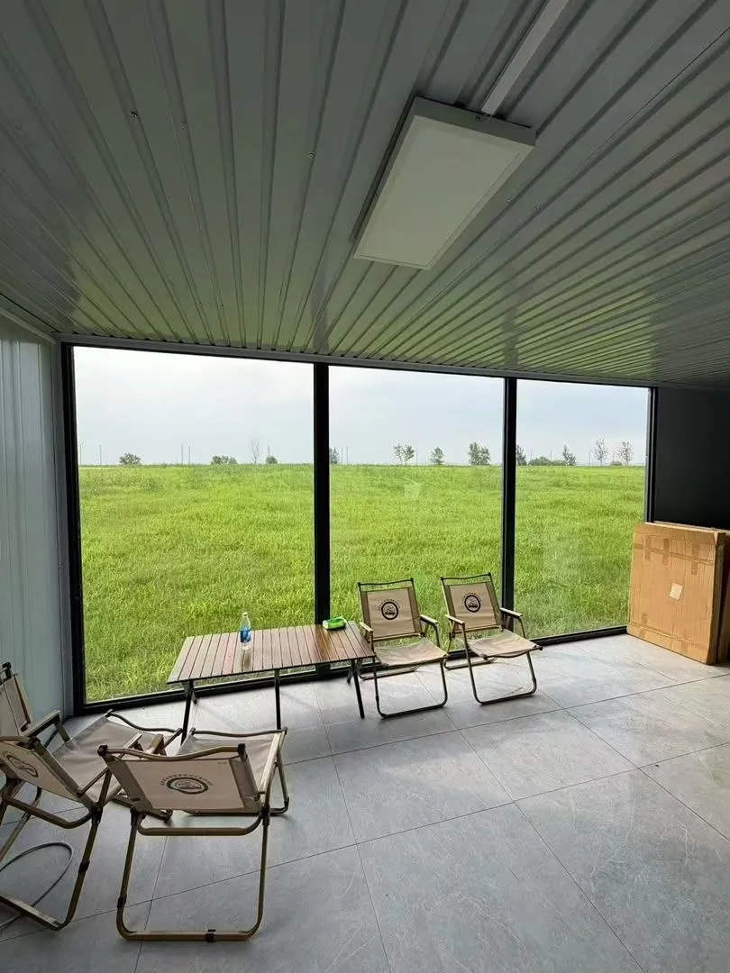 Interior de un módulo con ventanal panorámico hacia un campo verde
